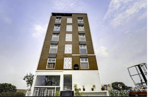 un grand bâtiment avec des fenêtres sur le côté dans l'établissement Fly Inn, à Bangalore