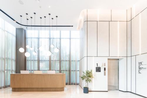 an office lobby with a reception desk and windows at Mii Hotel Srinakarin in Bangna