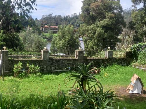 a woman sitting in the grass under a bridge at Bruton resorts in Kodaikānāl