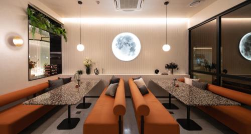 a living room with two tables and a couch at Mii Hotel Srinakarin in Bangna