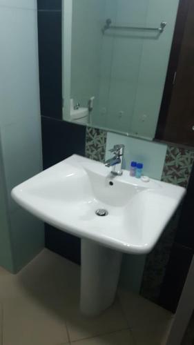 a white sink in a bathroom with a mirror at Vacay Lettings - Silicon Oasis Budget Friendly Studio in Dubai