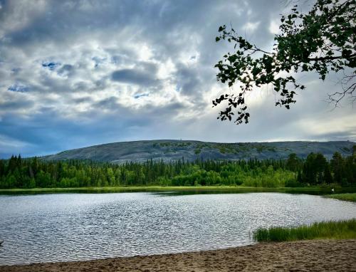 a large lake with a mountain in the background at Lapland Lodge Pyhä Ski in, sauna, free WiFi, national park - Lapland Villas in Pyhätunturi