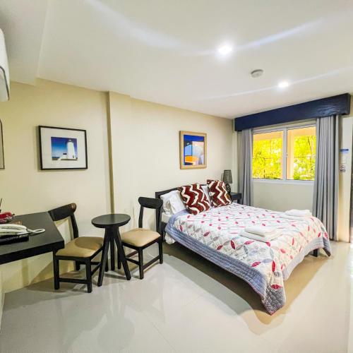 a bedroom with a bed and a desk at Casa Cecilia Hotel in Bantay