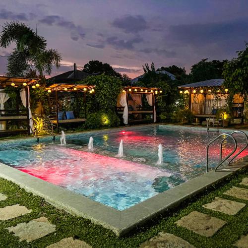 a swimming pool with a fountain in the middle at Casa Cecilia Hotel in Bantay