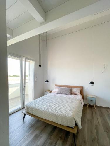 ein Schlafzimmer mit einem großen Bett und einem großen Fenster in der Unterkunft Casa moderna per vacanze rilassanti in San Martino in Fiume