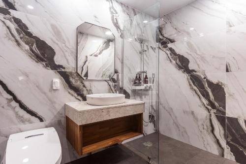 a bathroom with a toilet and a sink and a mirror at Gwangju HOUND Hotel in Gwangju