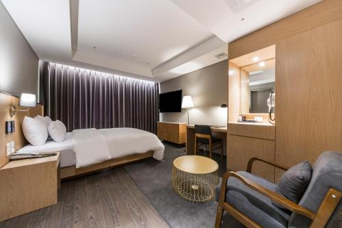 a hotel room with a bed and a desk at Gwangju HOUND Hotel in Gwangju