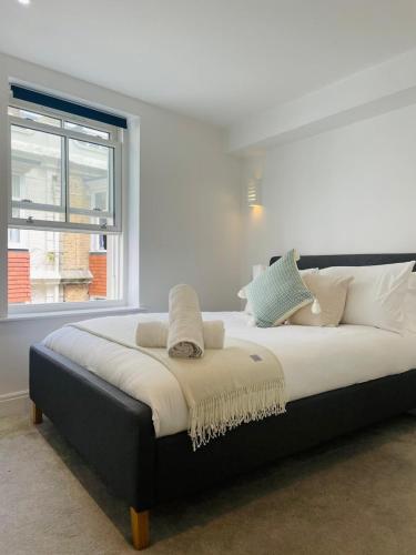 ein großes Bett in einem Zimmer mit Fenster in der Unterkunft The Square Bournemouth in Bournemouth