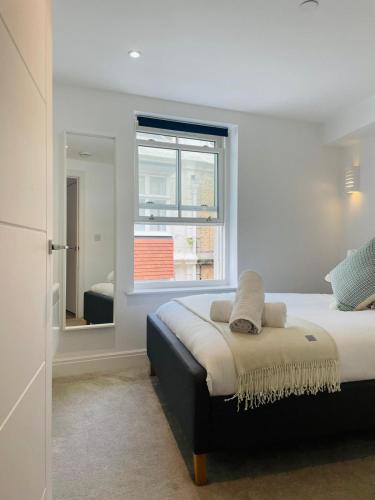 Schlafzimmer mit einem großen Bett und einem Fenster in der Unterkunft The Square Bournemouth in Bournemouth