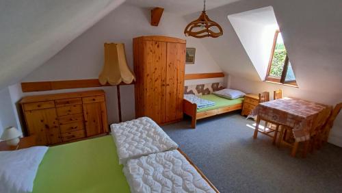 een slaapkamer met een bed, een bureau en een tafel bij Atrium House - Netolice in Netolice