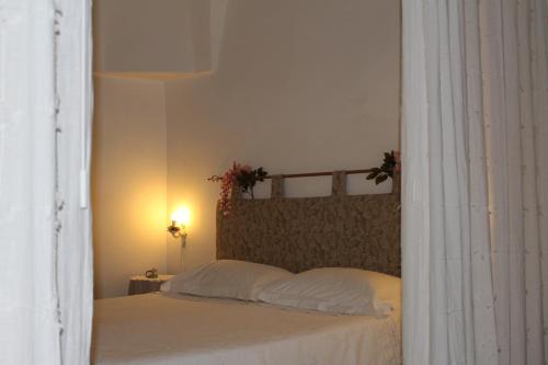 オストゥーニにあるDimora "Bianca Ostuni"のベッドルーム1室(白いシーツと花のベッド付)