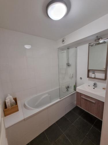 une salle de bain blanche avec une baignoire et un lavabo dans l'établissement Studio AVEC TERRASSE Carry le Rouet, à Carry-le-Rouet
