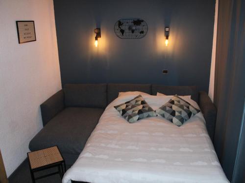 un lit dans une chambre avec deux oreillers dessus dans l'établissement Studio rénové 2019 · Ski aux pieds · Balcon · 4 pers - FR-1-181-1997, à La Plagne Tarentaise
