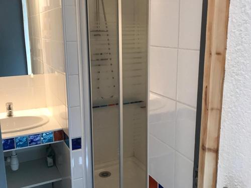 une douche avec une porte vitrée à côté d'un lavabo dans l'établissement Studio rénové 2019 · Ski aux pieds · Balcon · 4 pers - FR-1-181-1997, à La Plagne Tarentaise