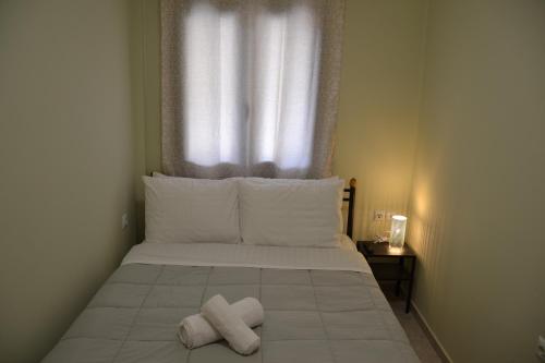 a bed with two towels on it with a window at Frygano Apartments 1 in Oítilon