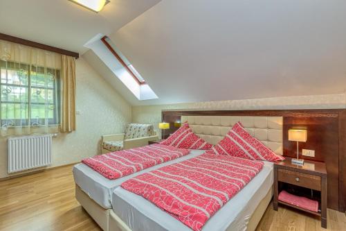 a bedroom with a large bed with red pillows at Pool Villa Silva Marija Apartments in Pišece