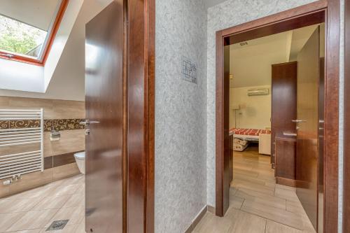 a hallway with a door to a bathroom with a bed at Pool Villa Silva Marija Apartments in Pišece