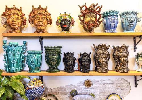 a bunch of vases are on a shelf at La dimora dei ricci in Santo Stefano di Camastra