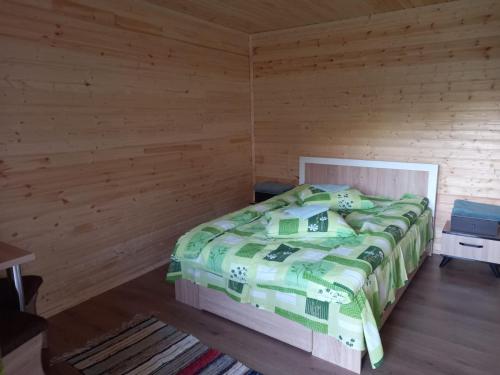 een slaapkamer met een bed in een houten kamer bij Cabanele Valea Bradului in Izvoru Mureşului