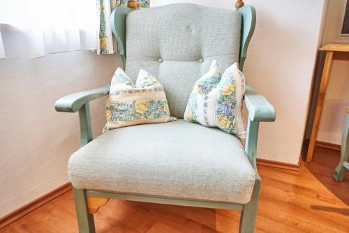 a blue chair with pillows on top of it at Chalet Haider in Saalbach Hinterglemm