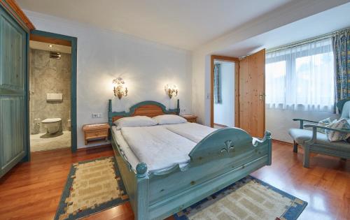 a bedroom with a blue bed and a bathroom at Chalet Haider in Saalbach Hinterglemm