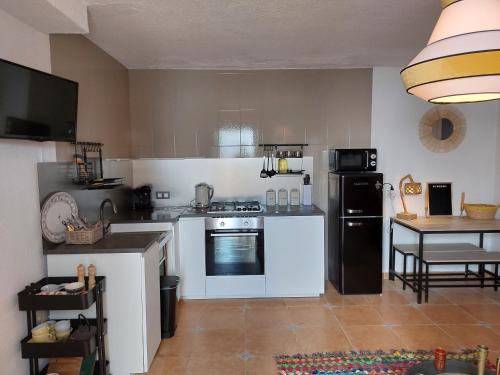 kuchnia z białymi urządzeniami i stołem w obiekcie Bohemian 2 bed Apartamento Amarillo w mieście Agua Amarga