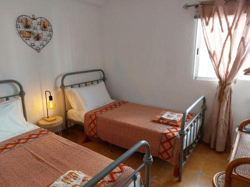 mały pokój z 2 łóżkami i oknem w obiekcie Bohemian 2 bed Apartamento Amarillo w mieście Agua Amarga