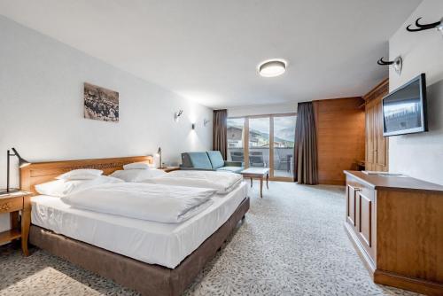 a hotel room with a bed and a television at Hotel Zum Gourmet in Seefeld in Tirol