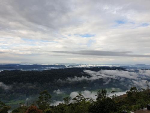 a view of a valley of clouds and trees at Seekend Holidays Munnar in Chinnakanal