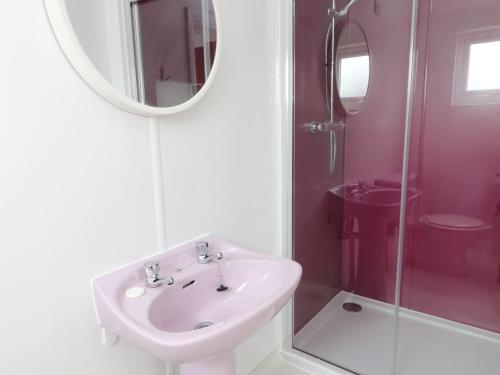 Baño blanco con lavabo y espejo en Angorfa - Aberdesach en Caernarfon