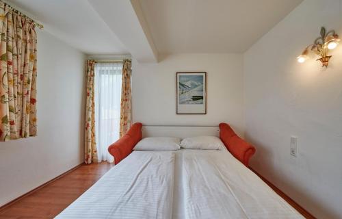 a white bed in a room with a window at Chalet Haider in Saalbach Hinterglemm