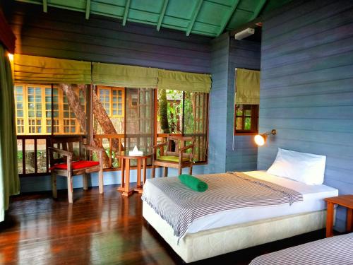 een slaapkamer met een bed in een blauwe kamer bij Permai Rainforest Resort in Santubong