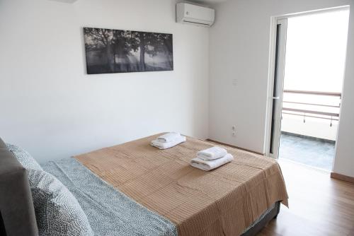 1 dormitorio con 1 cama con 2 toallas en Renovated apartment 5min from subway station 'Attiki' en Atenas