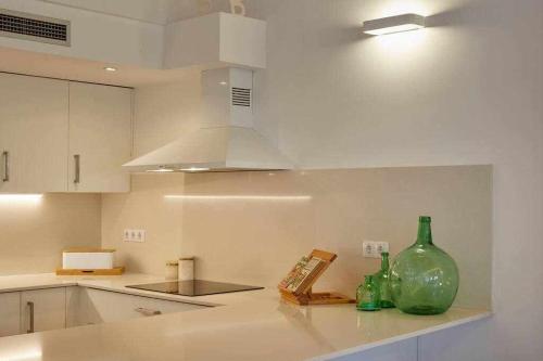 una cocina con 2 botellas de cristal verde en una encimera en Apartamento dúplex Rei Martí, Girona, en Girona
