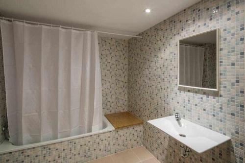 a bathroom with a sink and a mirror at Apartamento Riu Fluvià Girona in Girona