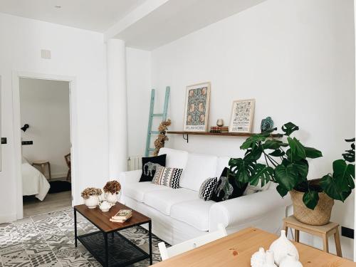 a living room with a white couch and a table at Estudio 33 in San Juan de la Arena