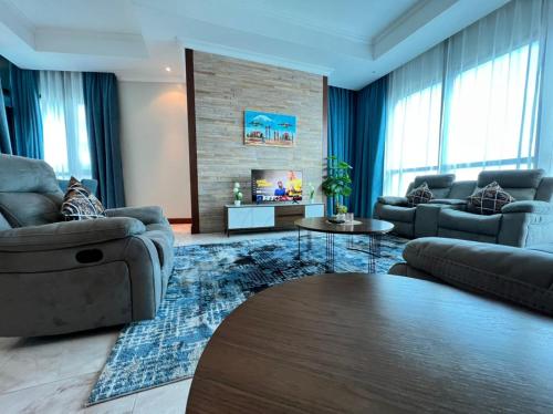 a living room with two couches and a tv at Fairview Luxury Apartments in Dar es Salaam