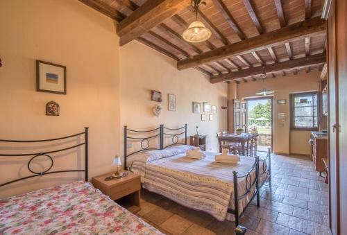 um quarto com 2 camas e uma mesa em Poggio Primo - Monolocale Saraceno em Castiglion Fibocchi