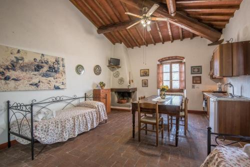 1 Schlafzimmer mit 2 Betten, einem Tisch und einer Küche in der Unterkunft Poggio Primo - Bilocale Brando in Castiglion Fibocchi
