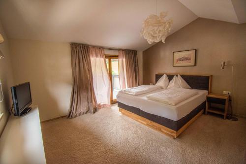 a bedroom with a bed and a tv and a window at Kramerhaus Viehhofen in Viehhofen