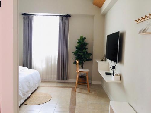 a bedroom with a bed and a flat screen tv at Village in Jinsha