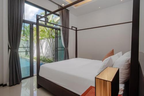 a bedroom with a bed and a large window at Two Bedroom Onyx Villa Nai Harn in Nai Harn Beach