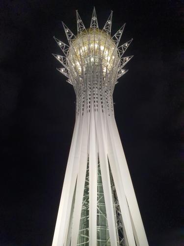 uma torre de relógio alta à noite com o céu em Apartment in heart of Astana em Astana