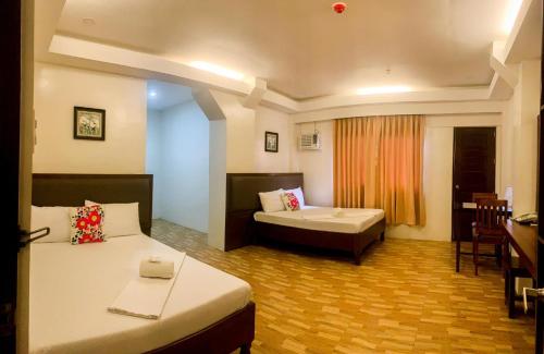 a hotel room with two beds and a table at Jurias Garden Hotel in El Nido