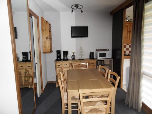 une cuisine et une salle à manger avec une table et des chaises dans l'établissement Studio divisible chaleureux · Au pied des pistes · Animaux admis - FR-1-181-2072, à La Plagne Tarentaise