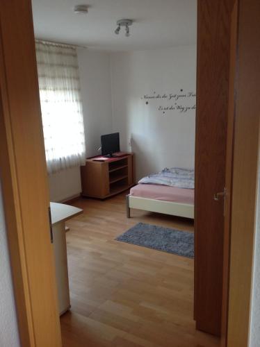 a room with a bedroom with a bed and a desk at Ruhige Wohnung in Schnaitheim bei Heidenheim in Heidenheim an der Brenz