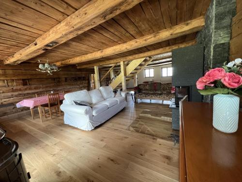 a living room with a white couch and a table at Chalet Schwendli in Schwarzsee