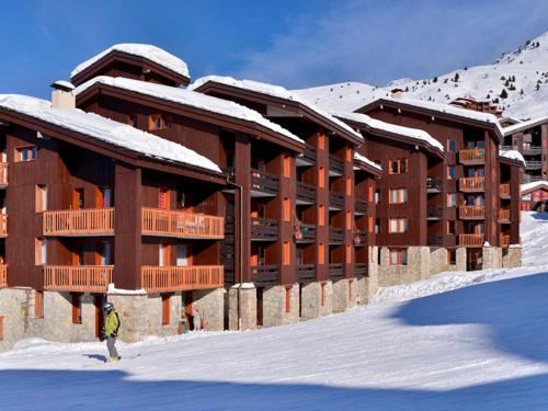 une personne debout dans la neige devant un bâtiment dans l'établissement Studio fonctionnel - au pied des pistes, casier à skis, animaux admis - FR-1-181-2181, à La Plagne Tarentaise