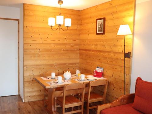 une salle à manger avec un mur en bois dans l'établissement Beau studio 4 pers, pied des pistes, balcon, casier à skis - FR-1-181-2137, à La Plagne Tarentaise