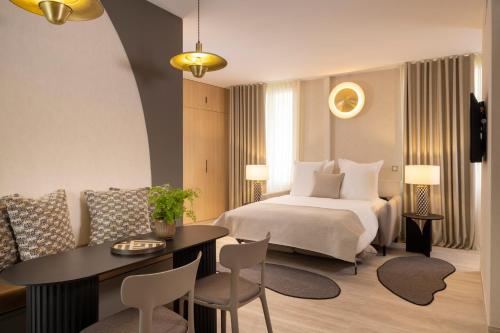 a hotel room with a bed and a table and chairs at Yuna Saint-Honoré - Serviced Apartments in Paris